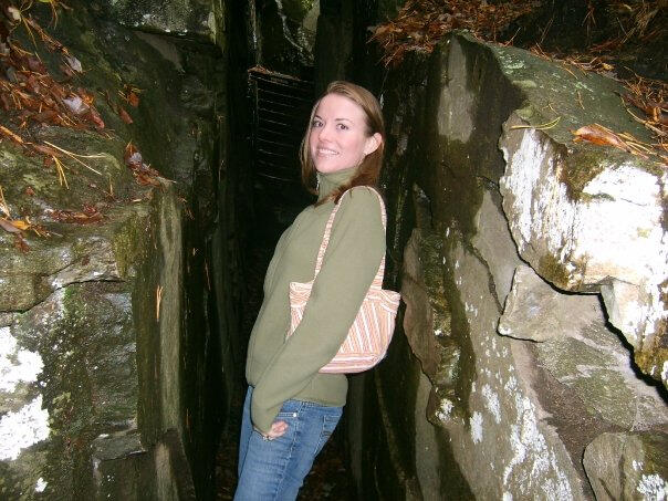 Smiling woman standing in alley-like passageway between two rock formations